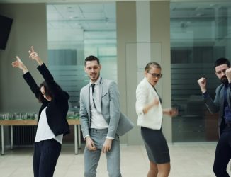 Coworkers dancing together at a company holiday party in a modern event space