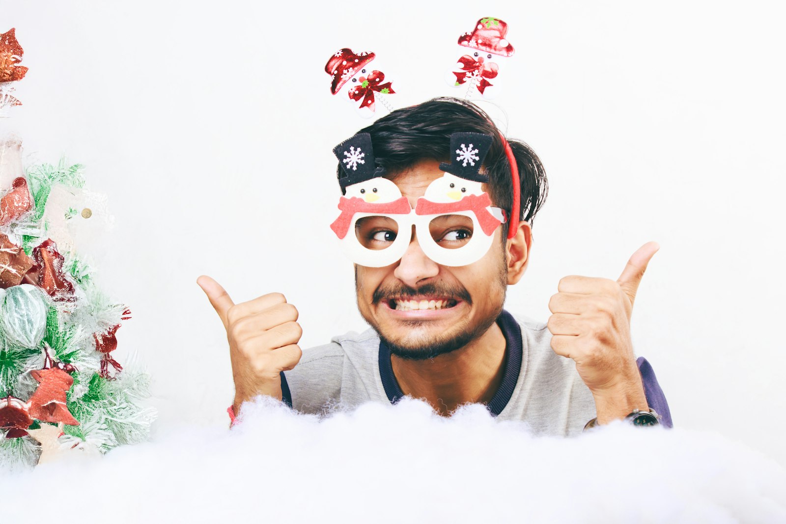 Guest posing with festive holiday glasses, a fun photo booth prop for an office holiday party